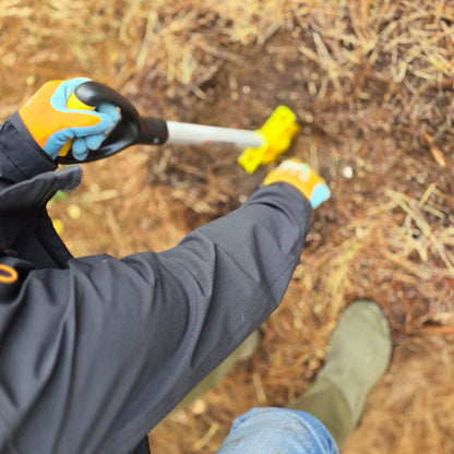 Man bending to plant a tree sapling with PLANTEM Short tool in woodland