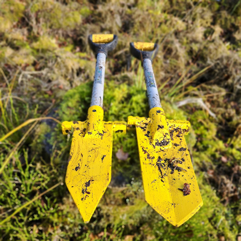 PLANTEM Short Spear and Short Dibber, tree planting spades, lying side by side on an old mossy tree stump