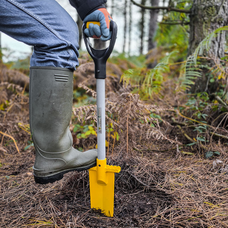 Person using PLANTEM short spear to make a slot ready to plant a tree sapling in woodland